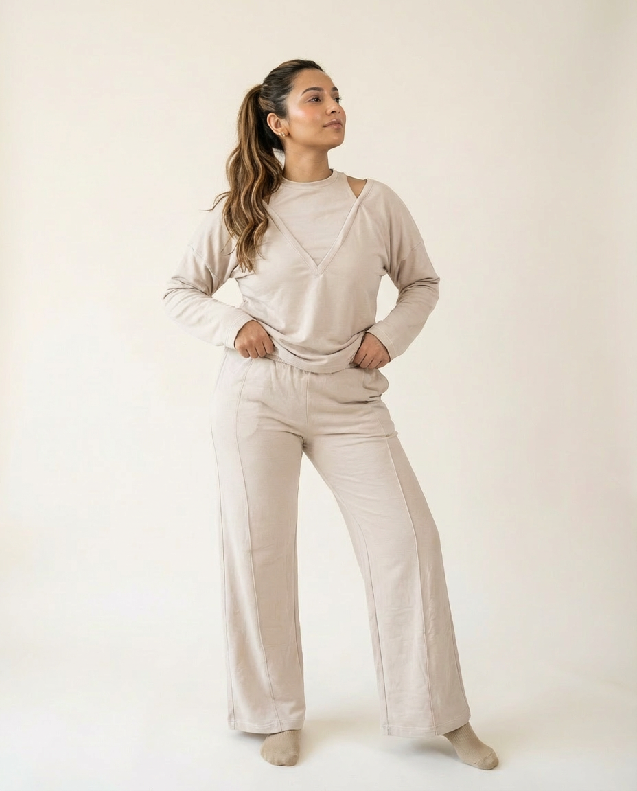 Woman wearing a beige outfit with wide-leg pants on a plain background