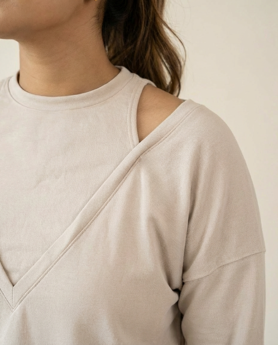 Beige long-sleeve top worn by a person on a neutral background