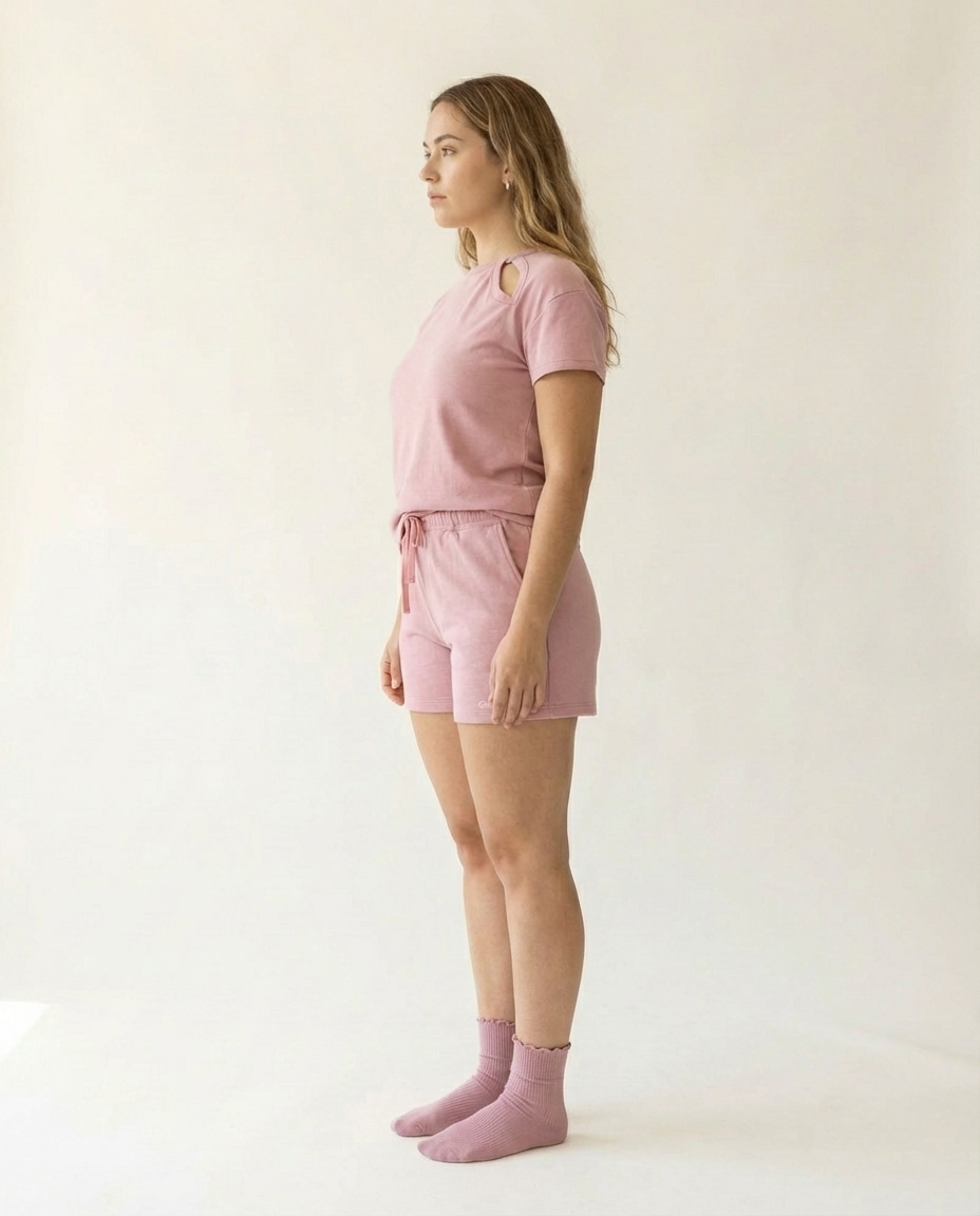 Woman wearing a pink outfit standing against a white background