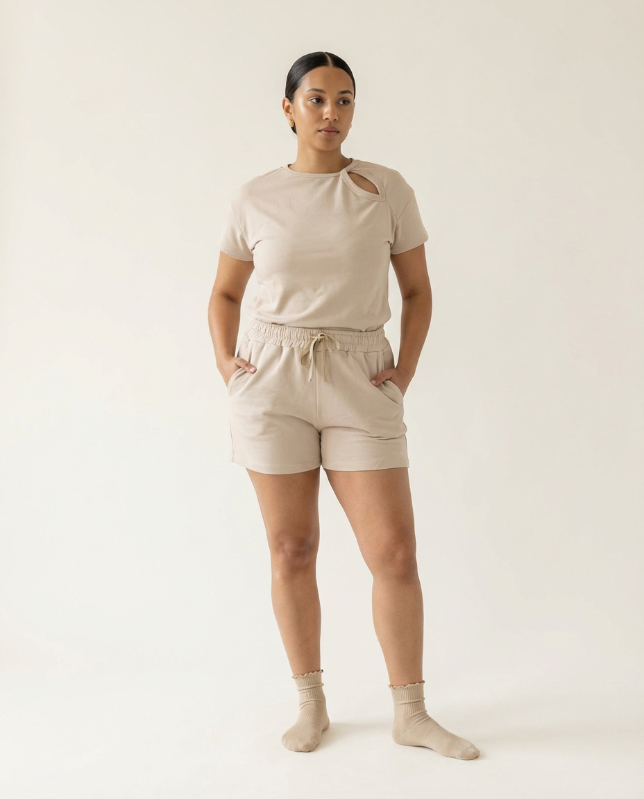 Woman wearing a beige t-shirt and shorts set on a white background
