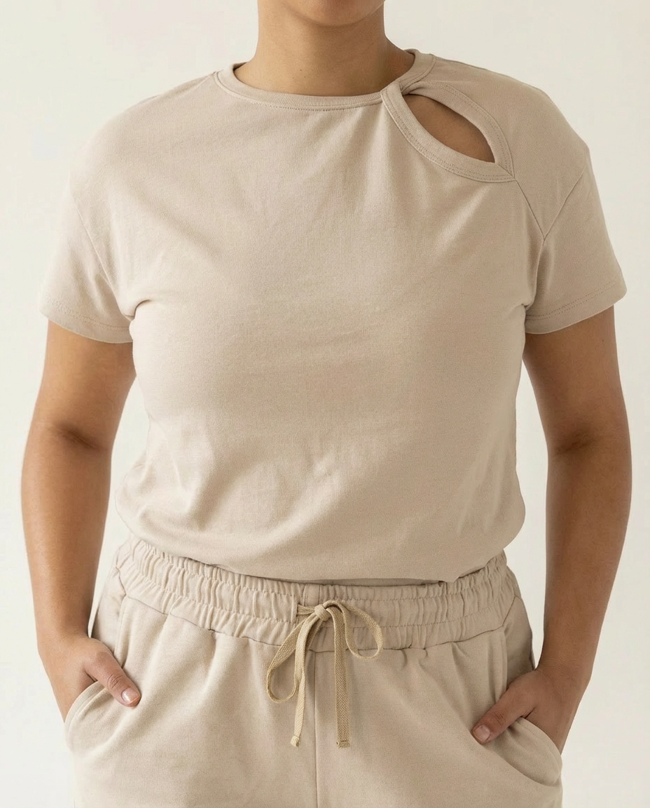 Person wearing a beige t-shirt and pants against a plain background