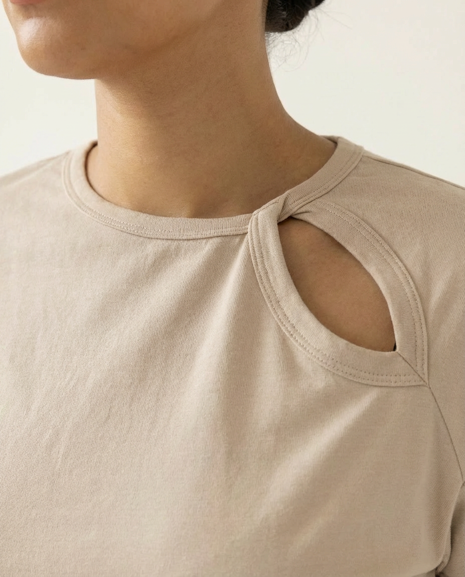 Beige t-shirt with cut-out shoulder design worn by a person